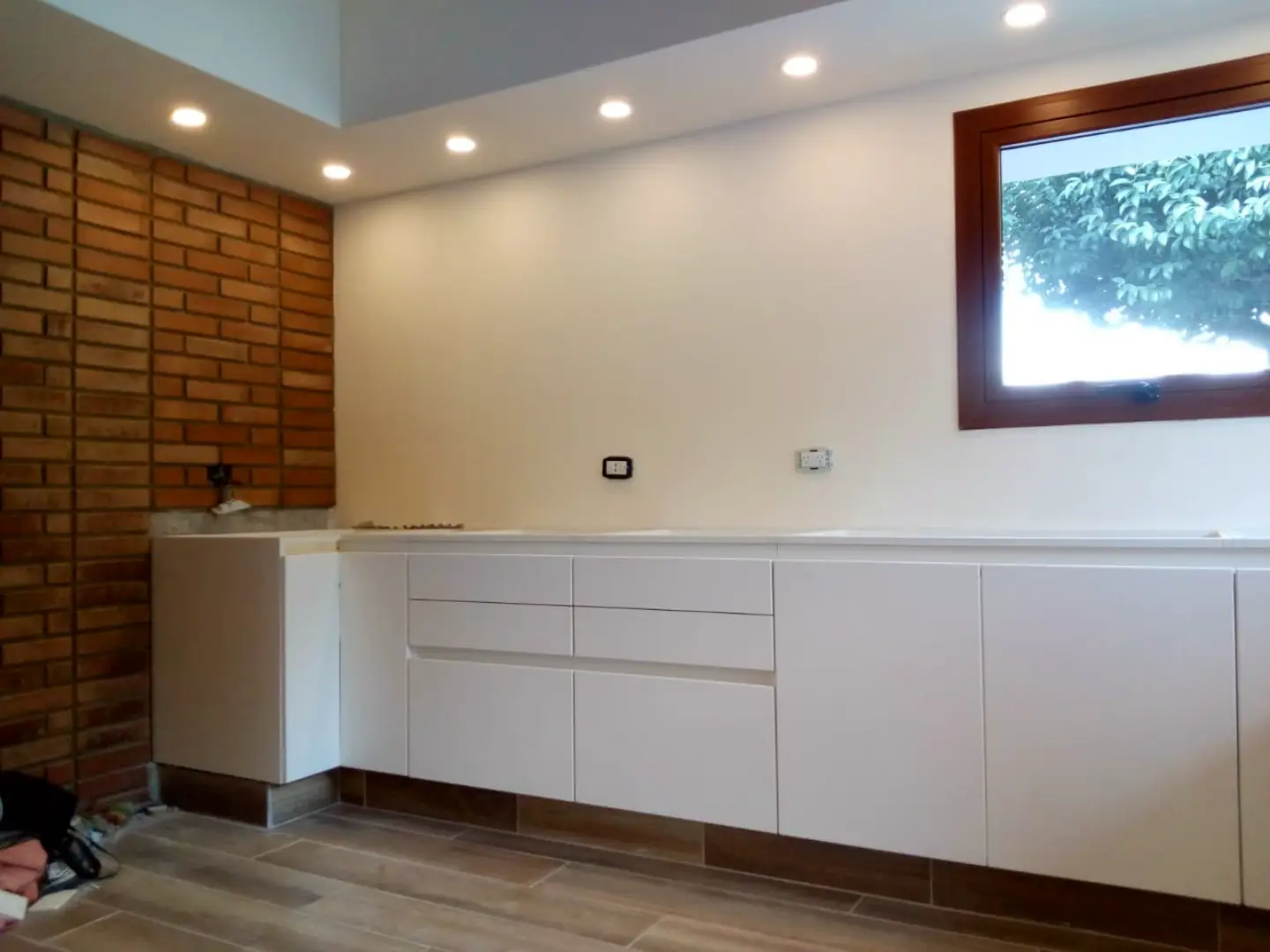 Muebles de cocina blancos y pared de ladrillo